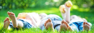 Children feet in green grass